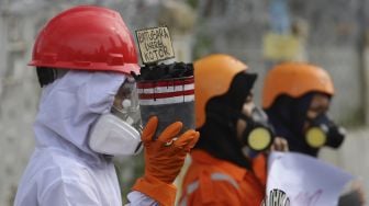 Aktivis Wahana Lingkungan Hidup Indonesia (Walhi) menggelar aksi di depan gedung Kementerian Energi dan Sumber Daya Mineral Republik Indonesia, Jakarta, Jumat (11/12/2020). [Suara.com/Angga Budhiyanto]