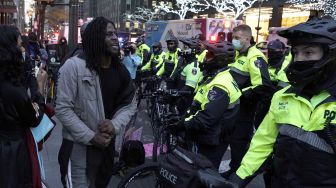 Seorang pengunjuk rasa berteriak pada petugas NYPD setelah sebuah mobil menabrak beberapa pengunjuk rasa Black Lives Matter pada 11 Desember 2020. [TIMOTHY A. CLARY / AFP]
