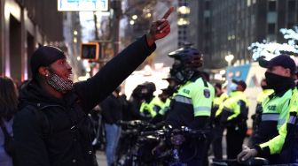 Seorang pengunjuk rasa berteriak pada petugas NYPD setelah sebuah mobil menabrak beberapa pengunjuk rasa Black Lives Matter pada 11 Desember 2020. [TIMOTHY A. CLARY / AFP]
