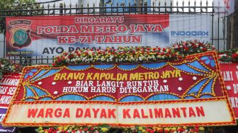 Salah satu karangan bunga dari warga Dayak Kalimantan yang menghiasi halaman depan Polda Metro Jaya, Jakarta Selatan, (12/12). [Suara.com/Alfian Winanto]