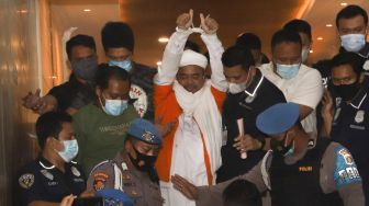 Imam besar FPI Habib Rizieq Shihab menggunakan baju tahanan usai diperiksa penyidik Polda Metro Jaya, Minggu (13/12/2020) dini hari.  [Suara.com/Alfian Winanto]