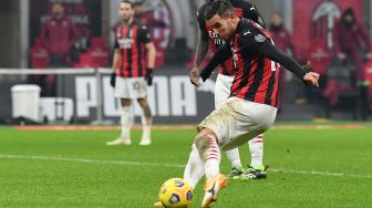 Bek AC Milan, Theo Hernandez, menembak untuk menyamakan kedudukan pertandingan sepak bola Serie A Italia AC Milan melawan Parma di stadion San Siro, Milan, Italia, Senin (14/12) dini hari WIB. Isabella BONOTTO / AFP