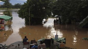 Warga duduk di tempat yang lebih tinggi saat banjir menggenangi permukiman di Kampung Sewu, Jebres, Solo, Jawa Tengah, Senin (14/12/2020).  ANTARA FOTO/Maulana Surya