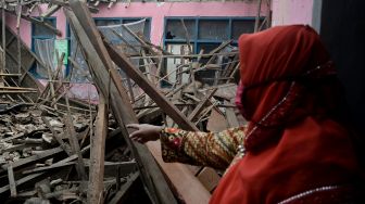 Seorang guru melihat reruntuhan bangunan di SDN Bakakan Loa 2, Pangatikan, Kabupaten Garut, Jawa Barat, Selasa (15/12/2020). [ANTARA FOTO/Candra Yanuarsyah]