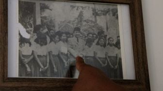 Petugas rumah pengasingan Bung Karno menunjukkan foto Presiden Pertama Indonesia Soekarno saat bersama dengan pelajar SMA di Kota Ende, NTT Rabu (16/12/2020).  [ANTARA FOTO/Kornelis Kaha]