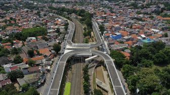 Foto udara sejumlah kendaraan melintas di dekat proyek pembangunan jalan layang tak sebidang tapal kuda Lenteng Agung, Jakarta, Rabu (16/12/2020). [Suara.com/Angga Budhiyanto]