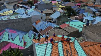 Foto udara petugas PPSU mengecat atap hunian warga di RT 012, RW 001 Kelurahan Lenteng Agung, Jagakarsa, Jakarta, Rabu (16/12/2020). [Suara.com/Angga Budhiyanto]