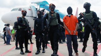 Petugas Detasemen Khusus (Densus) 88 membawa terduga teroris dari Lampung setibanya di Bandara Soekarno Hatta, Tangerang, Banten, Rabu (16/12/2020). [ANTARA FOTO/Muhammad Iqbal]