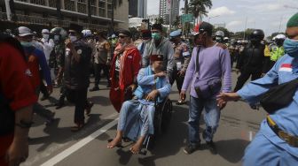 Aparat kepolisian membubarkan paksa massa aksi 1812 yang akan menggelar aksi unjuk rasa di kawasan Patung Kuda Arjuna Wiwaha, Jakarta, Jumat (18/12/2020). [Suara.com/Angga Budhiyanto]