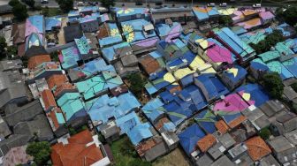 Foto udara atap hunian warga yang dicat di RT 012, RW 001 Kelurahan Lenteng Agung, Jagakarsa, Jakarta, Rabu (16/12/2020). Pemprov DKI Jakarta mengecat sebanyak 168 atap rumah di RW 01, 02, 03 dan 05, Kelurahan Lenteng Agung sebagai upaya untuk memperindah Kota Jakarta Selatan jika dilihat dari atas jalan layang (flyover) tapal kuda. [Suara.com/Angga Budhiyanto]