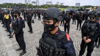 Anggota kepolisian mengikuti Apel Gelar Pasukan Operasi Lilin Jaya 2020 di kawasan Monumen Nasional (Monas), Jakarta, Senin (21/12/2020).  [ANTARA FOTO/Hafidz Mubarak]
