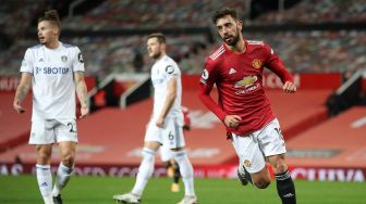 Gelandang Manchester United Bruno Fernandes (2L) mencetak gol ketiga timnya selama selama pertandingan sepak bola Liga Premier Inggris antara Manchester United melawan Leeds United di Old Trafford, Manchester, Inggris, Senin (20/12) dini hari WIB. 
Michael Regan / POOL / AFP