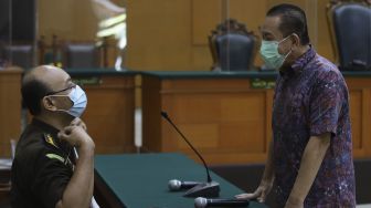 Terpidana kasus cessie Bank Bali Djoko Soegiarto Tjandra (kanan) selaku terdakwa perkara suap kepada jaksa dan perwira tinggi Polri serta pemufakatan jahat, berbincang dengan jaksa penuntut umum sebelum menjalani sidang pembacaan vonis di Pengadilan Negeri Jakarta Timur, Selasa (22/12/2020). [Suara.com/Angga Budhiyanto]