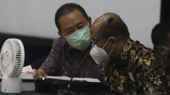 Terpidana kasus cessie Bank Bali Djoko Soegiarto Tjandra (kiri) selaku terdakwa perkara suap kepada jaksa dan perwira tinggi Polri serta pemufakatan jahat, berdiskusi dengan tim penasehat hukum sebelum menjalani sidang pembacaan vonis di Pengadilan Negeri Jakarta Timur, Selasa (22/12/2020). [Suara.com/Angga Budhiyanto]