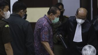 Terpidana kasus cessie Bank Bali Djoko Soegiarto Tjandra (tengah) selaku terdakwa perkara suap kepada jaksa dan perwira tinggi Polri serta pemufakatan jahat, berjalan meninggalkan ruang sidang usai menjalani sidang pembacaan vonis di Pengadilan Negeri Jakarta Timur, Selasa (22/12/2020). [Suara.com/Angga Budhiyanto]