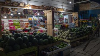 Pedagang buah menunggu pembeli di salah satu ruas jalan di Kota Poso, Kabupaten Poso, Sulawesi Tengah, Selasa (22/12/2020) malam.  [ANTARA FOTO/Basri Marzuki]
