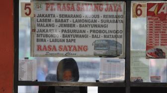 Seorang penjual tiket bus menunggu pembeli di Terminal Kampung Rambutan, Jakarta, Rabu (23/12/2020). [Suara.com/Angga Budhiyanto]