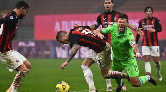 Gelandang AC Milan Rade Krunic (tengah) menghadang pemain depan Lazio Ciro Immobile pada pertandingan Serie A Italia AC Milan melawan Lazio di Stadion San Siro, Milan, Italia, Kamis (24/12) dini hari WIB. [Marco BERTORELLO / AFP]
