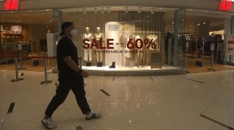 Pengunjung melintasi gerai pakaian yang memberikan potongan harga di Senayan City Mall, Jakarta, Jumat (25/12/2020). [Suara.com/Angga Budhiyanto]