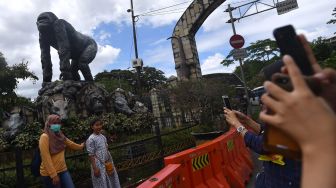 Warga berfoto di kawasan Taman Margasatwa Ragunan, Jakarta Selatan, Jumat (25/12/2020).  [ANTARA FOTO/Sigid Kurniawan]