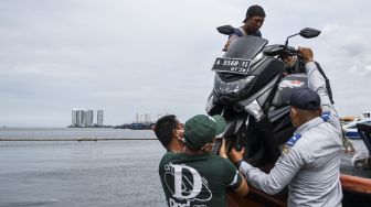 Awak kapal dibantu petugas Dinas Perhubungan Provinsi DKI Jakarta menurunkan sepeda motor dari kapal asal Kepulauan Seribu setibanya di Dermaga Kali Adem, Muara Angke, Jakarta, Sabtu (26/12/2020). [ANTARA FOTO/M Risyal Hidayat]