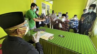 Penghulu memimpin prosesi akad nikah yang hanya dihadiri oleh mempelai laki-laki dan sejumlah saksi di Kantor Urusan Agama Kecamatan Pakel, Tulungagung, Jawa Timur, Sabtu (26/12/2020). [ANTARA FOTO/Destyan Sujarwoko]