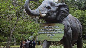 Pengunjung berswafoto di area Taman Margasatwa Ragunan, Jakarta, Sabtu (26/12/2020). [Suara.com/Angga Budhiyanto]