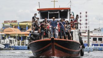 Sejumlah penumpang kapal dari Kepulauan Seribu tiba di Dermaga Kali Adem, Muara Angke, Jakarta, Sabtu (26/12/2020). [ANTARA FOTO/M Risyal Hidayat]