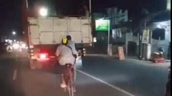 Aksi Berbahaya Pesepeda Melaju di Belakang Truk, Bikin Deg-degan