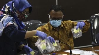 Komisioner Komnas HAM Choirul Anam (kanan) bersiap menunjukkan barang bukti hasil penyelidikan saat konferensi pers di Gedung Komisi Nasional Hak Asasi Manusia, Jakarta, Senin (28/12/2020). [Suara.com/Angga Budhiyanto]