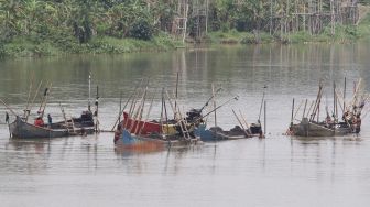 Pekerja menambang pasir menggunakan perahu di tengah aliran sungai Brantas, Kota Kediri, Jawa Timur, Senin (28/12/2020).  [ANTARA FOTO/Prasetia Fauzani]
