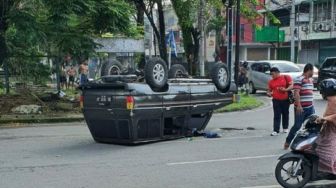 Nekat Terobos Lampu Merah, Mobil Kijang Kotak Terguling di Jalan Sutomo