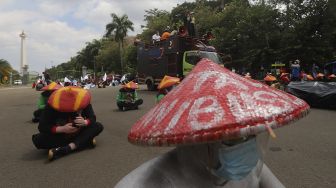 Sejumlah massa buruh yang tergabung dalam Konfederasi Serikat Pekerja Indonesia (KSPI) melakukan aksi unjuk rasa di kawasan Patung Kuda Arjuna Wiwaha, Jakarta, Selasa (29/12/2020). [Suara.com/Angga Budhiyanto]