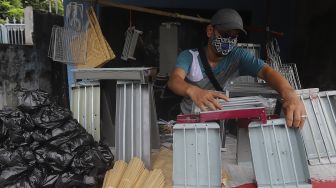 Pedagang alat panggang menata dagangannya di kawasan Pasar Minggu, Jakarta, Kamis (31/12/2020). [Suara.com/Angga Budhiyanto]