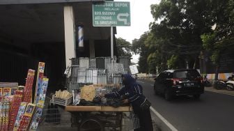 Pedagang alat panggang menata dagangannya di kawasan Pasar Minggu, Jakarta, Kamis (31/12/2020). [Suara.com/Angga Budhiyanto]