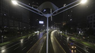 Petugas Satpol PP melaksanakan patroli  saat diberlakukannya Car Free Night (malam bebas kendaraan) dan Crowd Free Night (malam bebas keramaian) pada malam pergantian tahun di Jalan Sudirman, Jakarta, Kamis (31/12/2020). [Suara.com/Angga Budhiyanto]