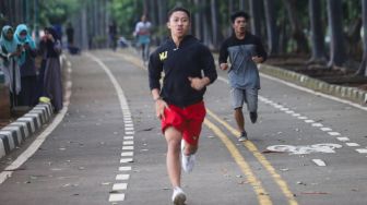 Warga berolahraga di kawasan Banjir Kanal Timur (BKT), Jakarta Timur, Jumat (1/1/2020). [Suara.com/Alfian Winanto]