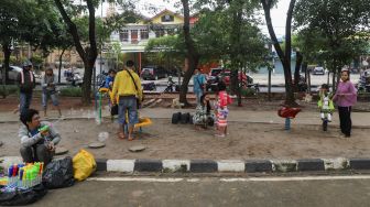 Anak - anak bermain di kawasan Banjir Kanal Timur (BKT), Jakarta Timur, Jumat (1/1/2020). [Suara.com/Alfian Winanto]