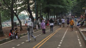 Warga memadati kawasan Banjir Kanal Timur (BKT), Jakarta Timur, Jumat (1/1/2020). [Suara.com/Alfian Winanto]
