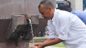 Warga berwudhu untuk melaksanakan shalat jumat di Masjid Agung At-Tin, Taman Mini, Jakarta Timur, Jumat (1/1/2021). [Suara.com/Alfian Winanto]