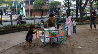 Anak - anak bermain di kawasan Banjir Kanal Timur (BKT), Jakarta Timur, Jumat (1/1/2020). [Suara.com/Alfian Winanto]