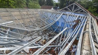 Sejumlah warga membantu menyelamatkan barang-barang pasca ambruknya atap ruang kelas SDN 1 Sukadana di Dusun Desa, Kabupaten Ciamis, Jawa Barat, Sabtu (2/1/2021). ANTARA FOTO/Adeng Bustomi