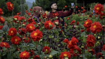 Wisatawan berswafoto saat mengunjungi Kamodjan Fillage, Samarang, Kabupaten Garut, Jawa Barat, Sabtu (2/1/2021). [ANTARA FOTO/Candra Yanuarsyah]