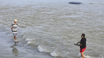 Warga melintasi jalan yang tergenang banjir akibat jebolnya tanggul Sungai Gelis di Dukuh Goleng, Pasuruan Lor, Jati, Kudus, Jawa Tengah, Minggu (3/1/2021). [ANTARA FOTO/Yusuf Nugroho]