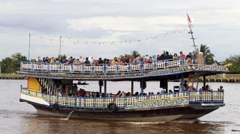 Puluhan wisatawan domestik menaiki kapal wisata di Sungai Kapuas, Pontianak, Kalimantan Barat, Minggu (3/1/2021). [ANTARA FOTO/Jessica Helena Wuysang]