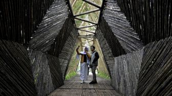 Wisatawan berswafoto saat mengunjungi Kamodjan Fillage, Samarang, Kabupaten Garut, Jawa Barat, Sabtu (2/1/2021). [ANTARA FOTO/Candra Yanuarsyah]