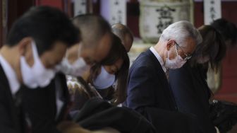 Orang-orang berdoa pada hari pertama kerja di tahun baru di kuil Kanda Myojin, Tokyo, Senin (4/1/2021). [Kazuhiro NOGI / AFP]