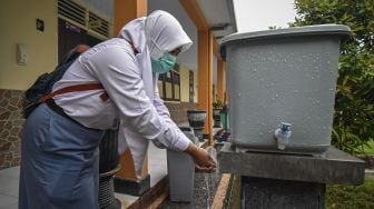 Siswi mencuci tangan sebelum masuk kelas saat hari pertama masuk sekolah pembelajaran tatap muka di SMAN 1 Mataram, NTB, Senin (4/1/2021). [ANTARA FOTO/Ahmad Subaidi]