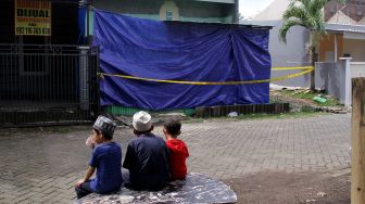 Sejumlah bocah duduk di dekat rumah terduga teroris yang dipasangi garis polisi usai penggerebekan di Perumahan Villa Mutiara, Kelurahan Bulurokeng, Kecamatan Biringkanaya, Makassar, Sulawesi Selatan, Rabu (6/1/2021). [ANTARA FOTO/Arnas Padda]