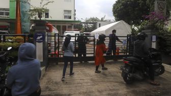 Warga menanyakan informasi tentang pelayanan kepada petugas di Puskesmas Duren Sawit, Jakarta Timur, Rabu (6/1/2021). [Suara.com/Angga Budhiyanto]